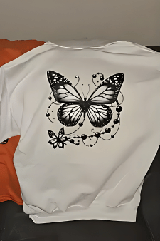 Großflächiger und detailreicher DTF Druck eines Schmetterling-Motivs auf dem Rücken eines weißen Hoodies.